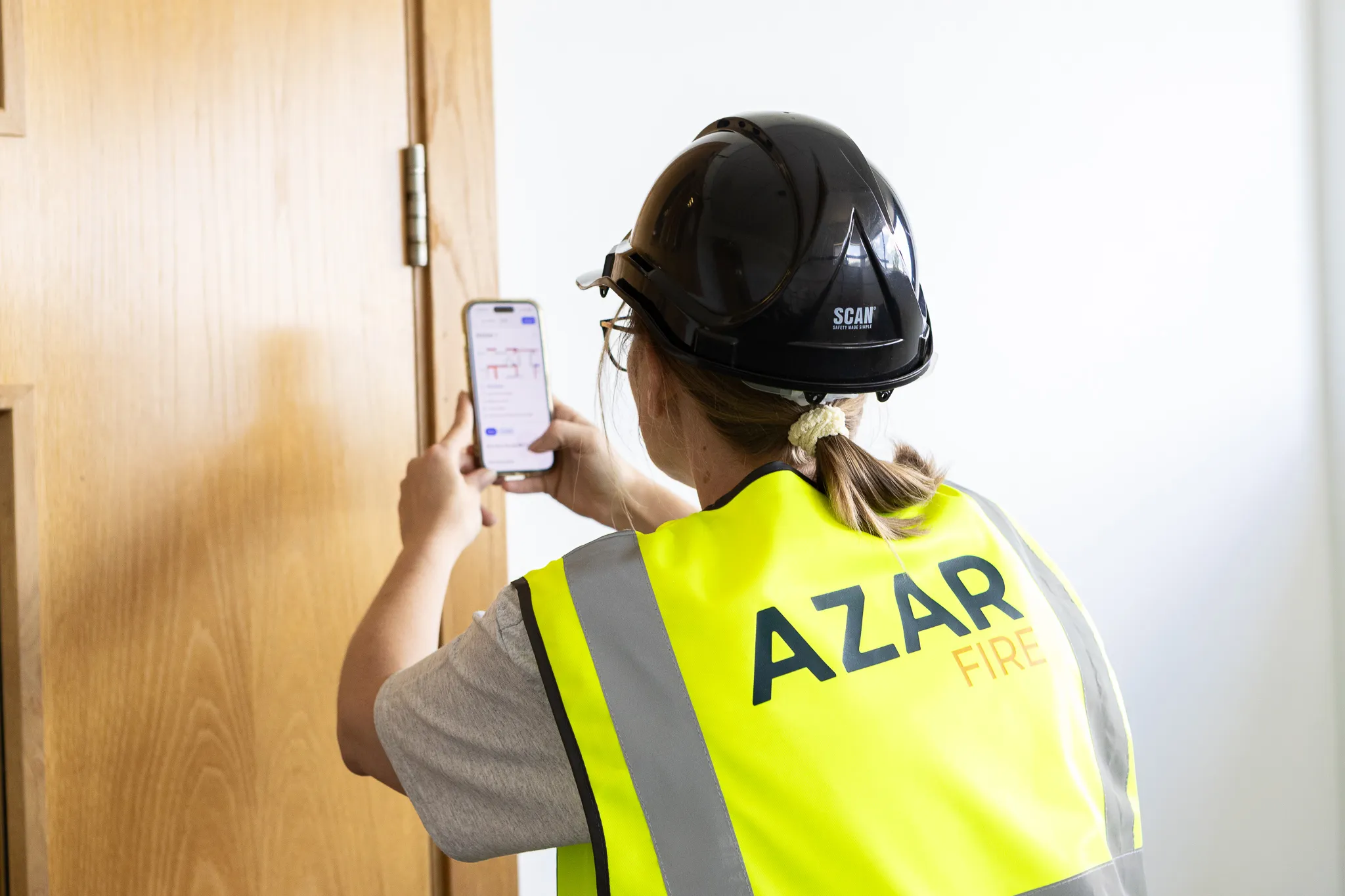 An Azar Fire surveyor logging a fire door on the survey app