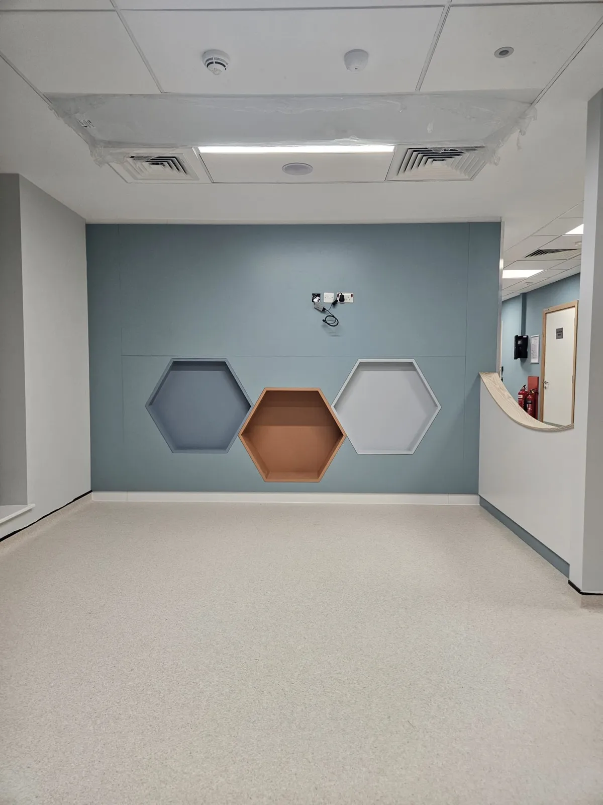 Bespoke reception joinery with a hexagonal feature wall