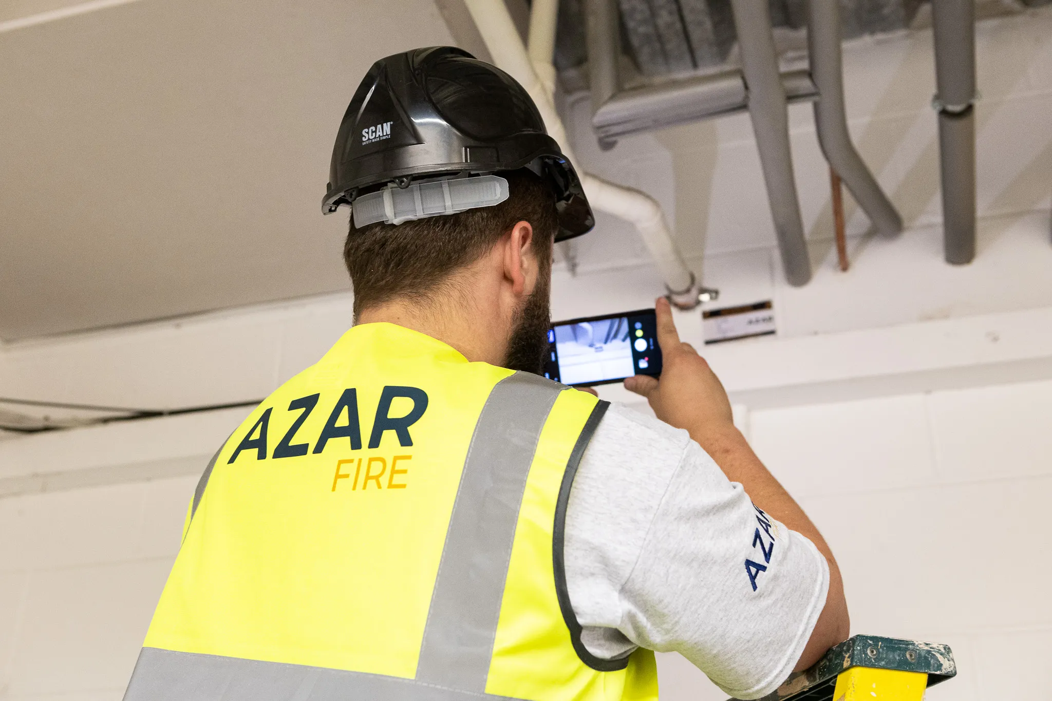 Azar Fire surveyor photographing overhead services during a passive fire protection survey