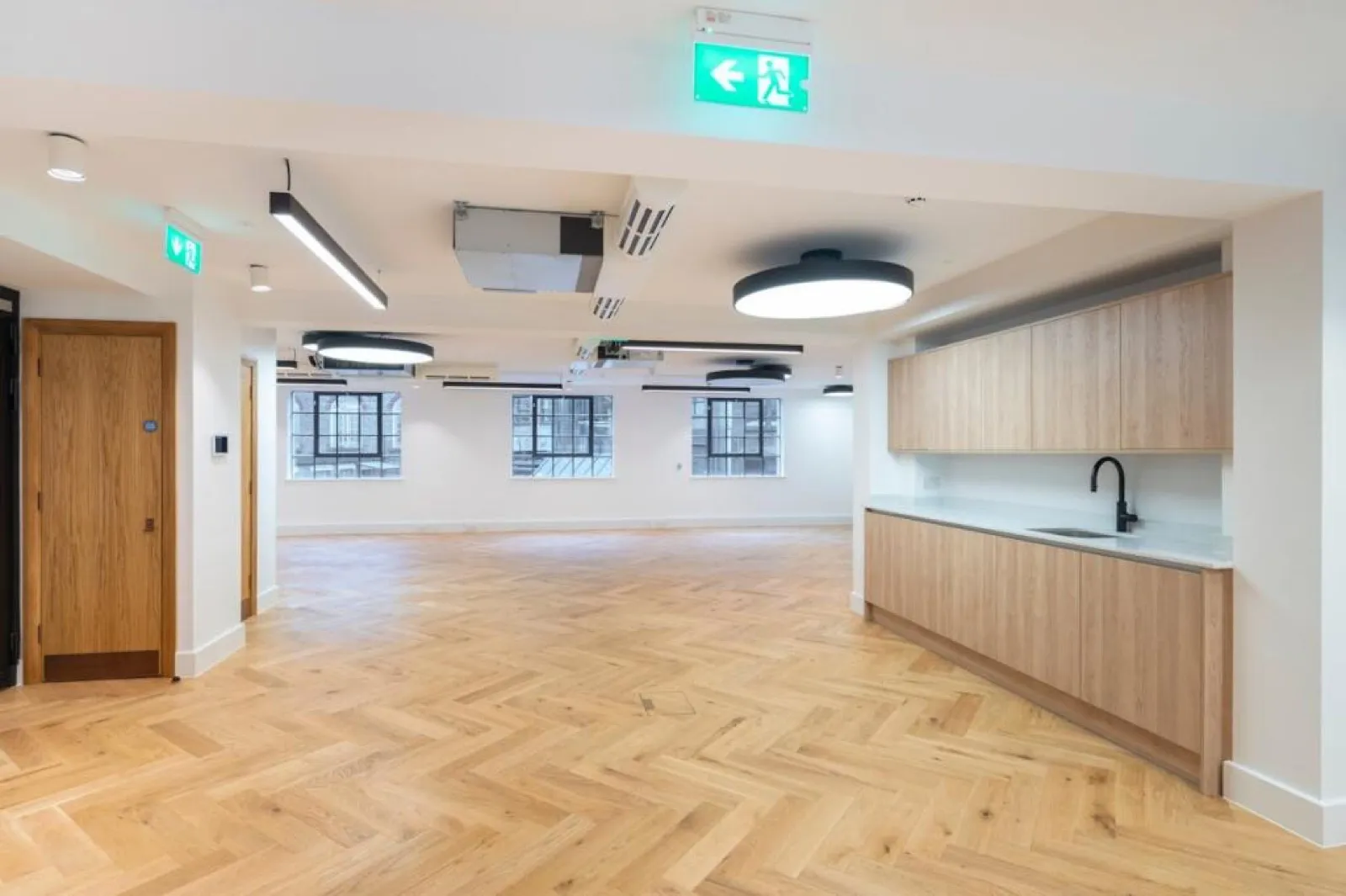 Refurbished CAT A+ office with herringbone oak flooring and an oak tea point